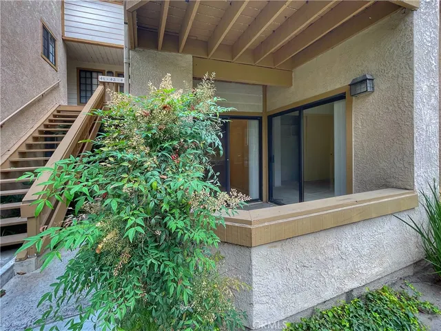 a house with a potted plant next to a yard