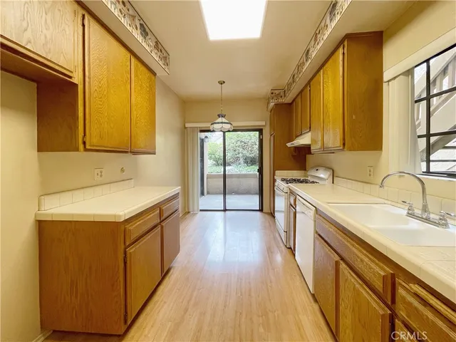 a view of a kitchen with a sink and wooden cabinets