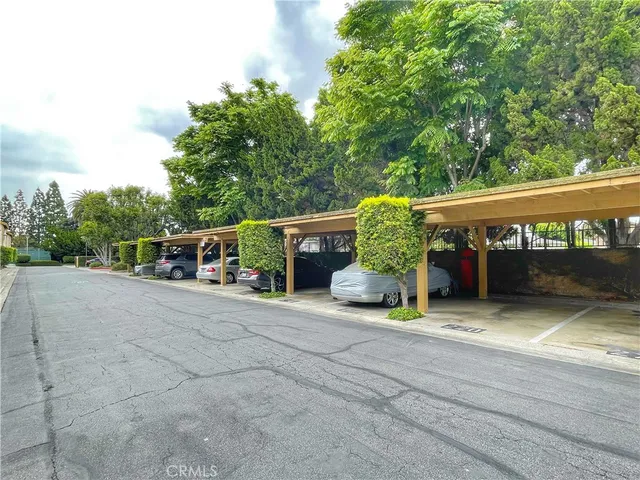 a view of a barn with big yard and large trees