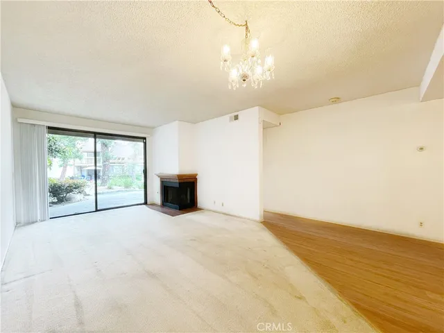 an empty room with chandelier fan and windows