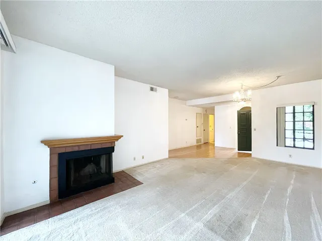a view of an empty room with a fireplace and a window