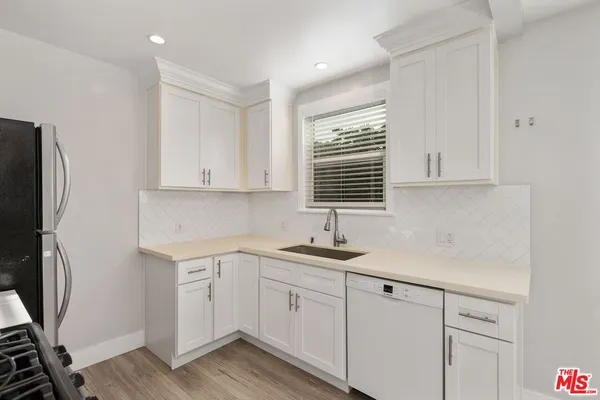 a kitchen with stainless steel appliances a stove a refrigerator and cabinets