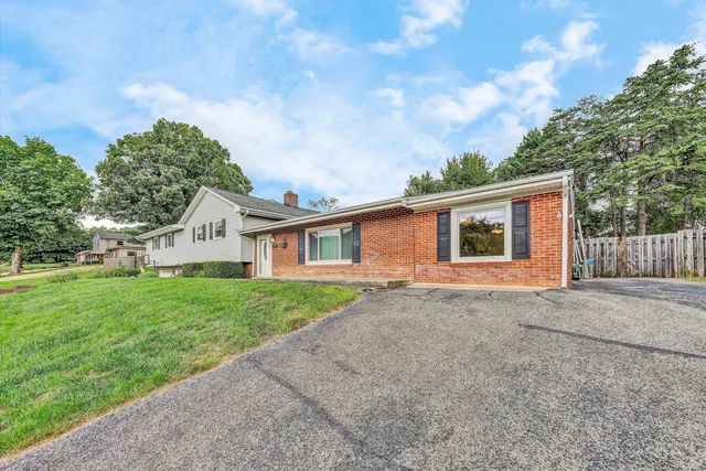 a view of a yard in front of a house with large tree