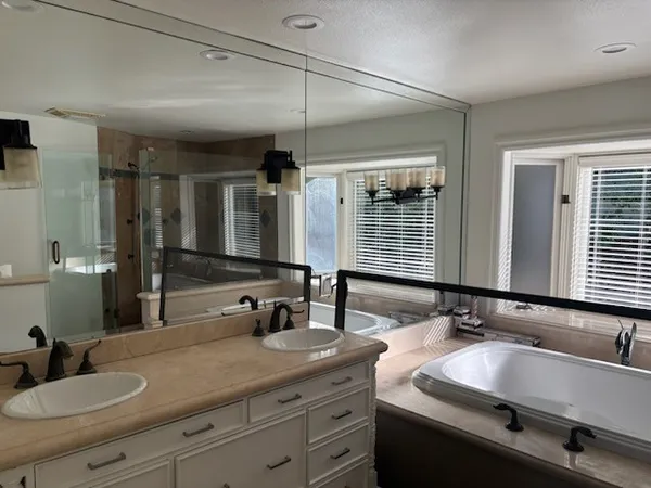 a bathroom with double vanity sinks and a mirror