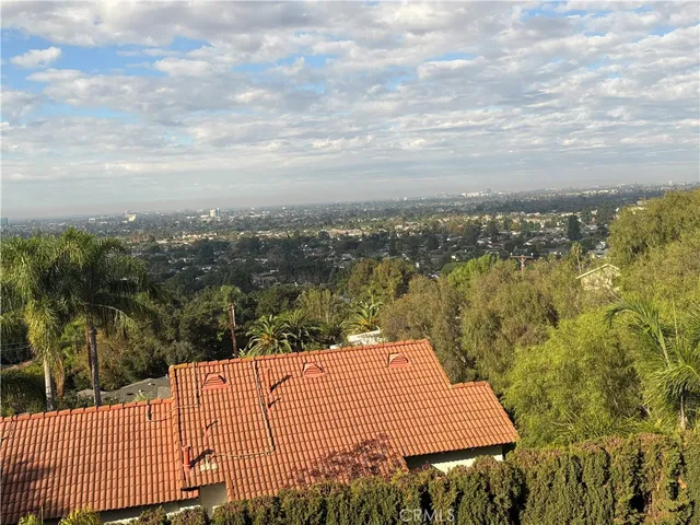 a view of a roof deck with couches and wooden fence