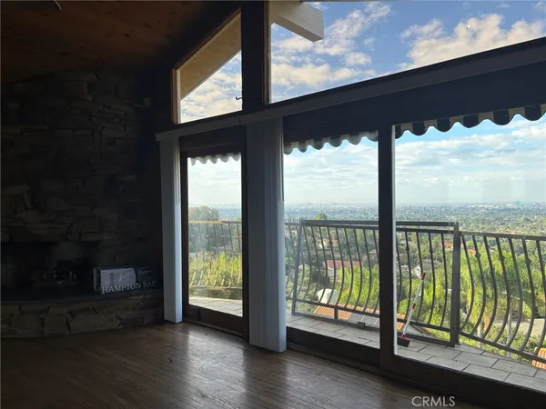 a view of an empty room with wooden floor and a floor to ceiling window