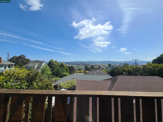 a balcony with wooden floor and city view