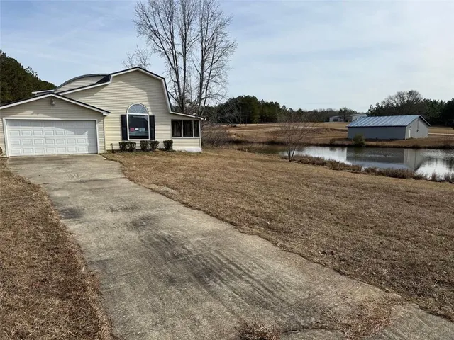 a view of house with river and trees in the background