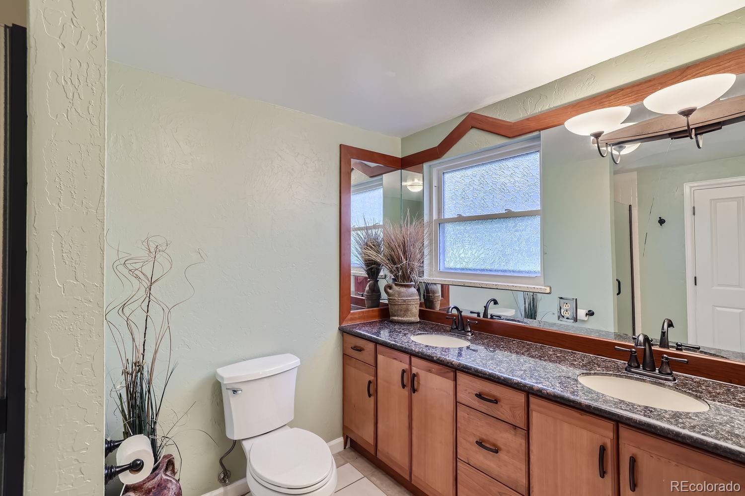 6227 Colorow Drive Morrison, CO 80465 - Photo 13 of 43 a bathroom with a granite countertop toilet sink and mirror