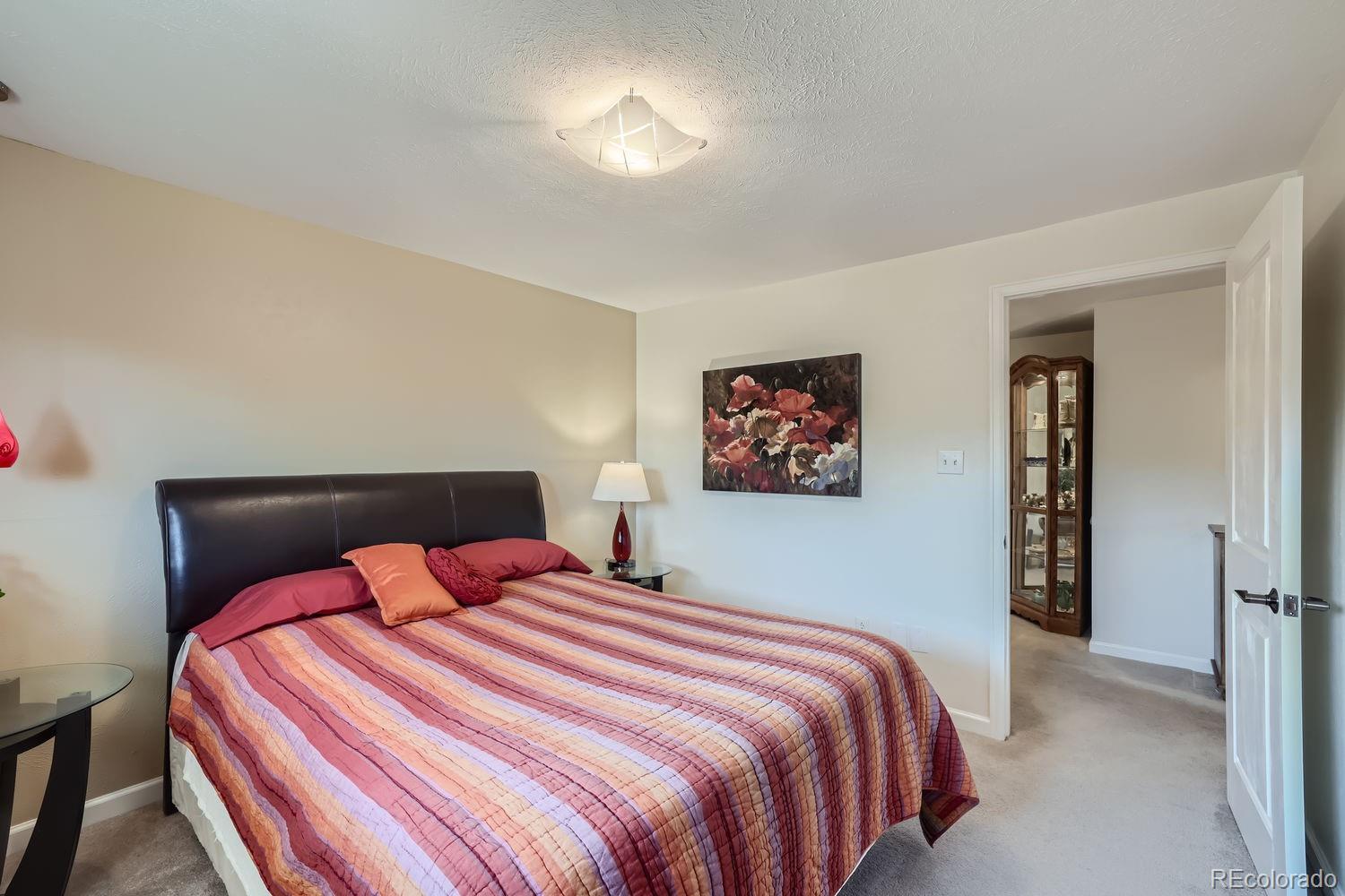 6227 Colorow Drive Morrison, CO 80465 - Photo 14 of 43 a bedroom with a bed and a chandelier