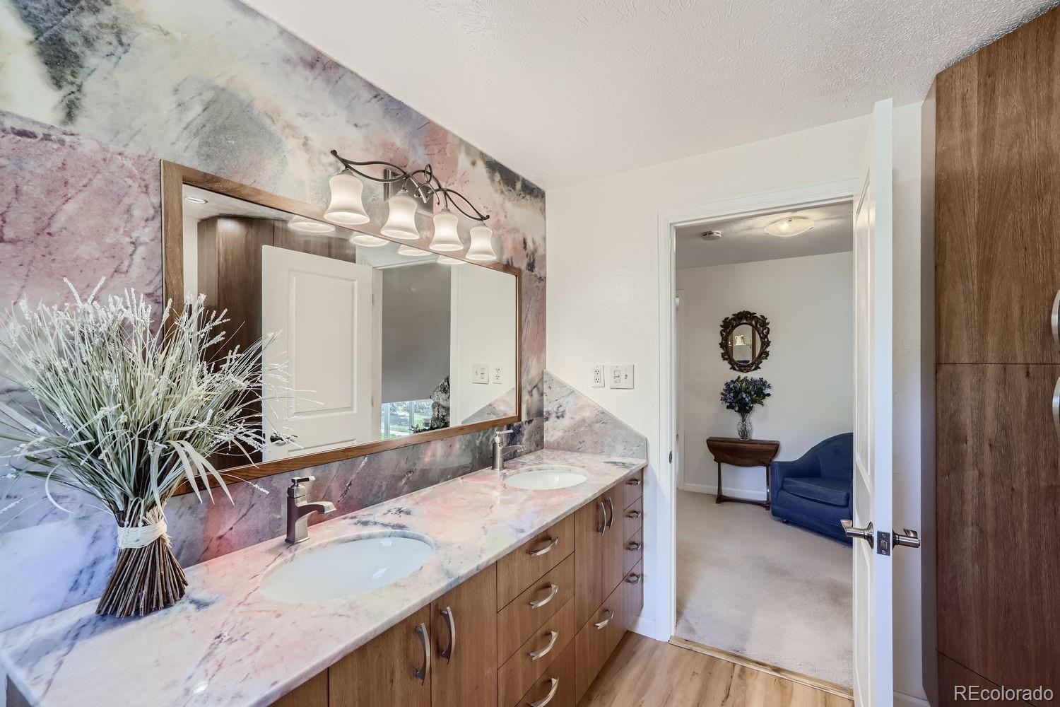 6227 Colorow Drive Morrison, CO 80465 - Photo 16 of 43 a bathroom with a granite countertop sink a large mirror and a shower
