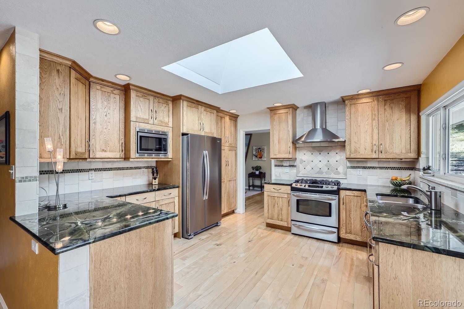 6227 Colorow Drive Morrison, CO 80465 - Photo 8 of 43 a kitchen with stainless steel appliances granite countertop a stove a refrigerator and a sink