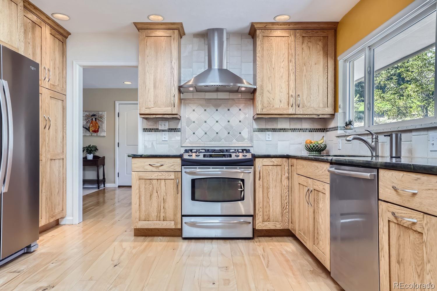 6227 Colorow Drive Morrison, CO 80465 - Photo 9 of 43 a kitchen with stainless steel appliances granite countertop a stove and a refrigerator