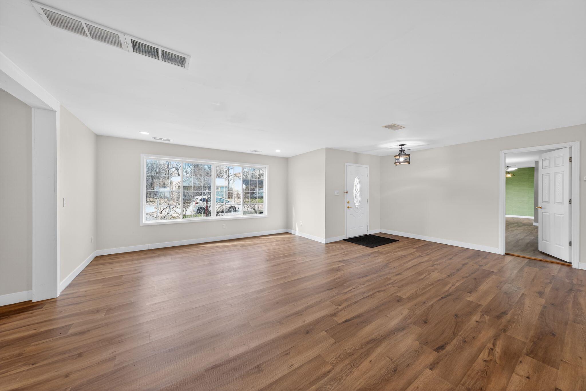 1908 Central Drive Gary, IN 46407 - Photo 5 of 29 an empty room with wooden floor and windows