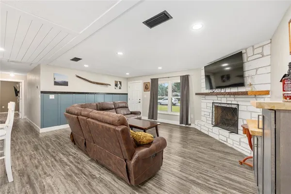 a living room with furniture a flat screen tv and a fireplace