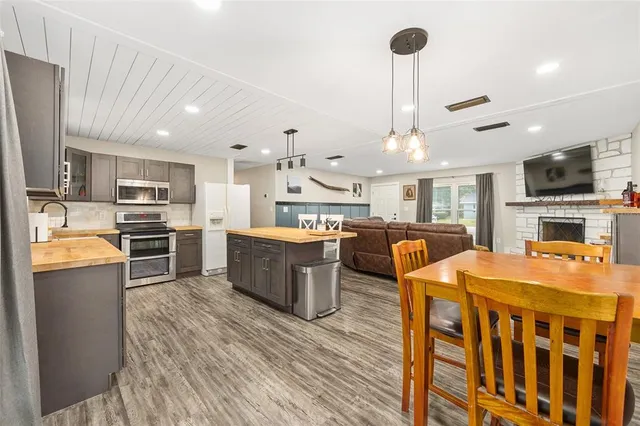 a large kitchen with a table chairs refrigerator and a sink