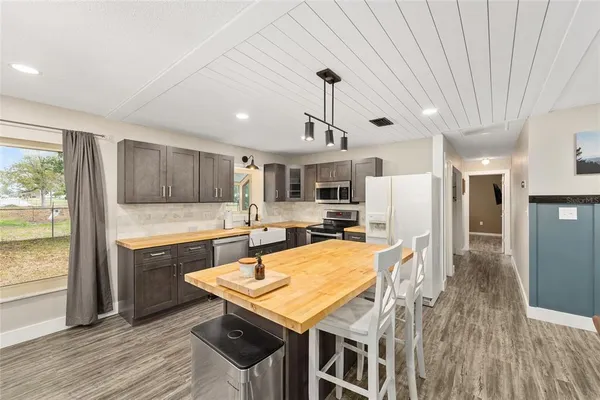 a kitchen with stainless steel appliances granite countertop a kitchen island a stove a table and chairs in it