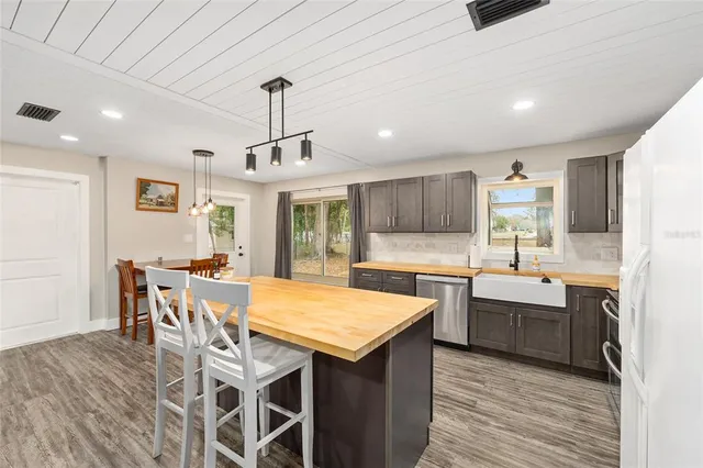 a kitchen with granite countertop a sink and a refrigerator