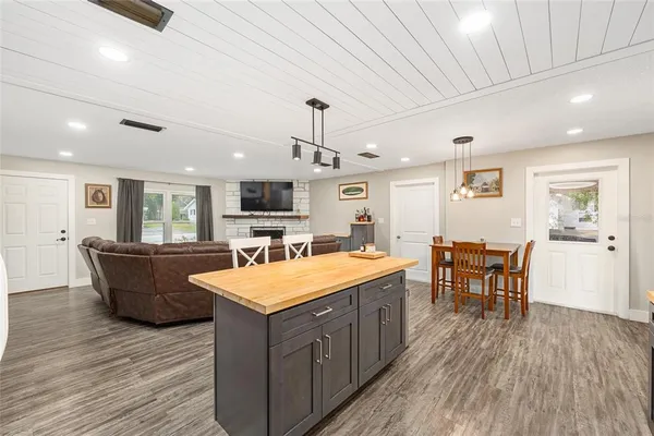 a large kitchen with kitchen island a wooden floor and white cabinets