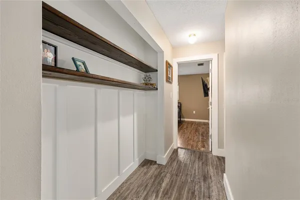 a view of a hallway with wooden floor and staircase
