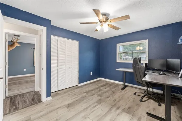 a workspace with chandelier fan and window