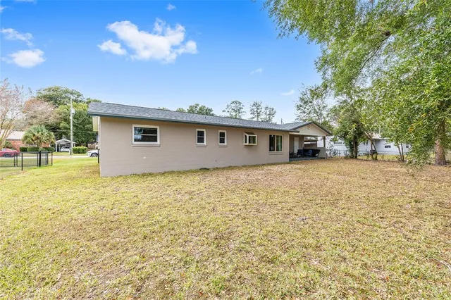 a view of house with backyard and tree