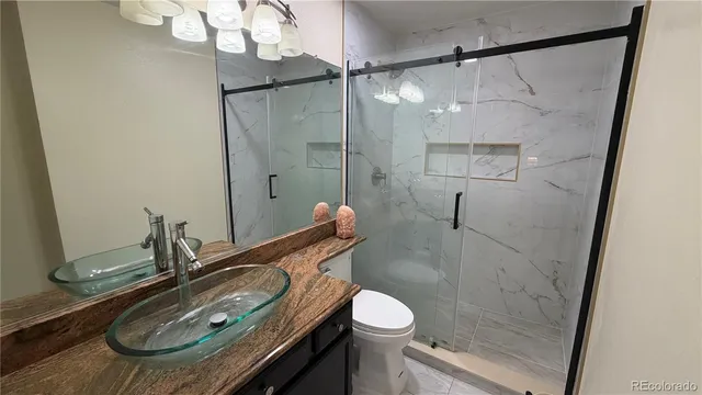 a bathroom with a sink a toilet and shower