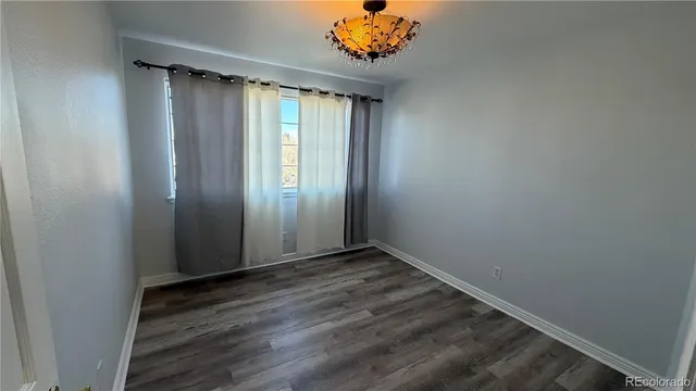 an empty room with wooden floor and a window