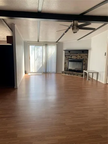 a view of an empty room with a fireplace and a window