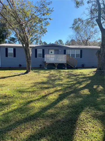 a view of a house with a large tree