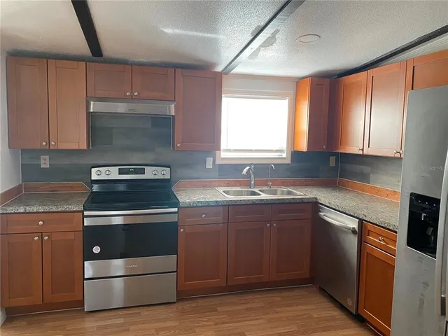 a kitchen with a stove sink and cabinets