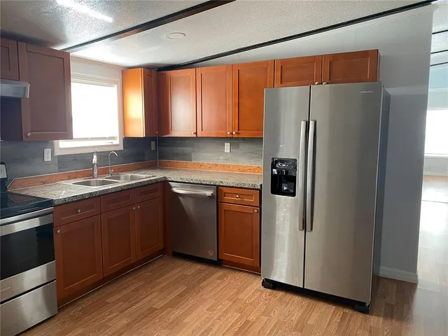 a kitchen with a refrigerator sink and cabinets