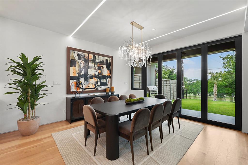 9457 Waterview Road Dallas, TX 75218 - Photo 4 of 25 Dining area featuring large-format sliding glass doors, light wood-finish flooring, and recessed linear lighting