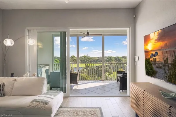 a living room with furniture and a floor to ceiling window
