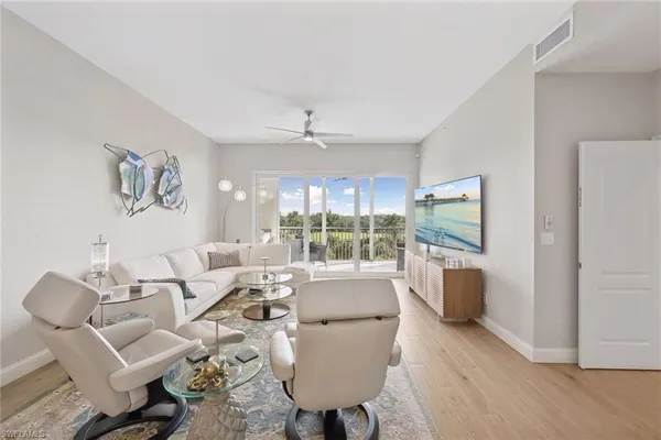 a living room with furniture a large window and a dining table
