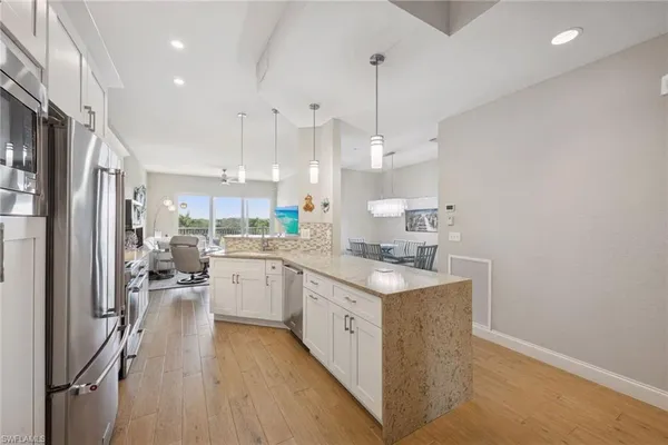 a kitchen with stainless steel appliances granite countertop a sink a stove and a wooden floors