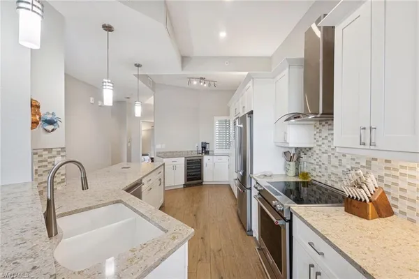 a view of a dining room and livingroom with furniture wooden floor a chandelier