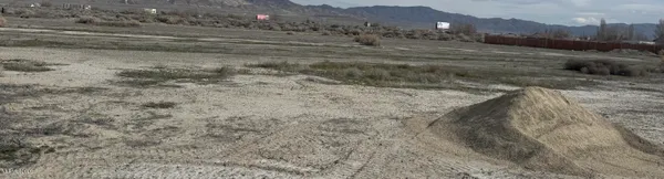 a view of a dry yard with mountains in the background