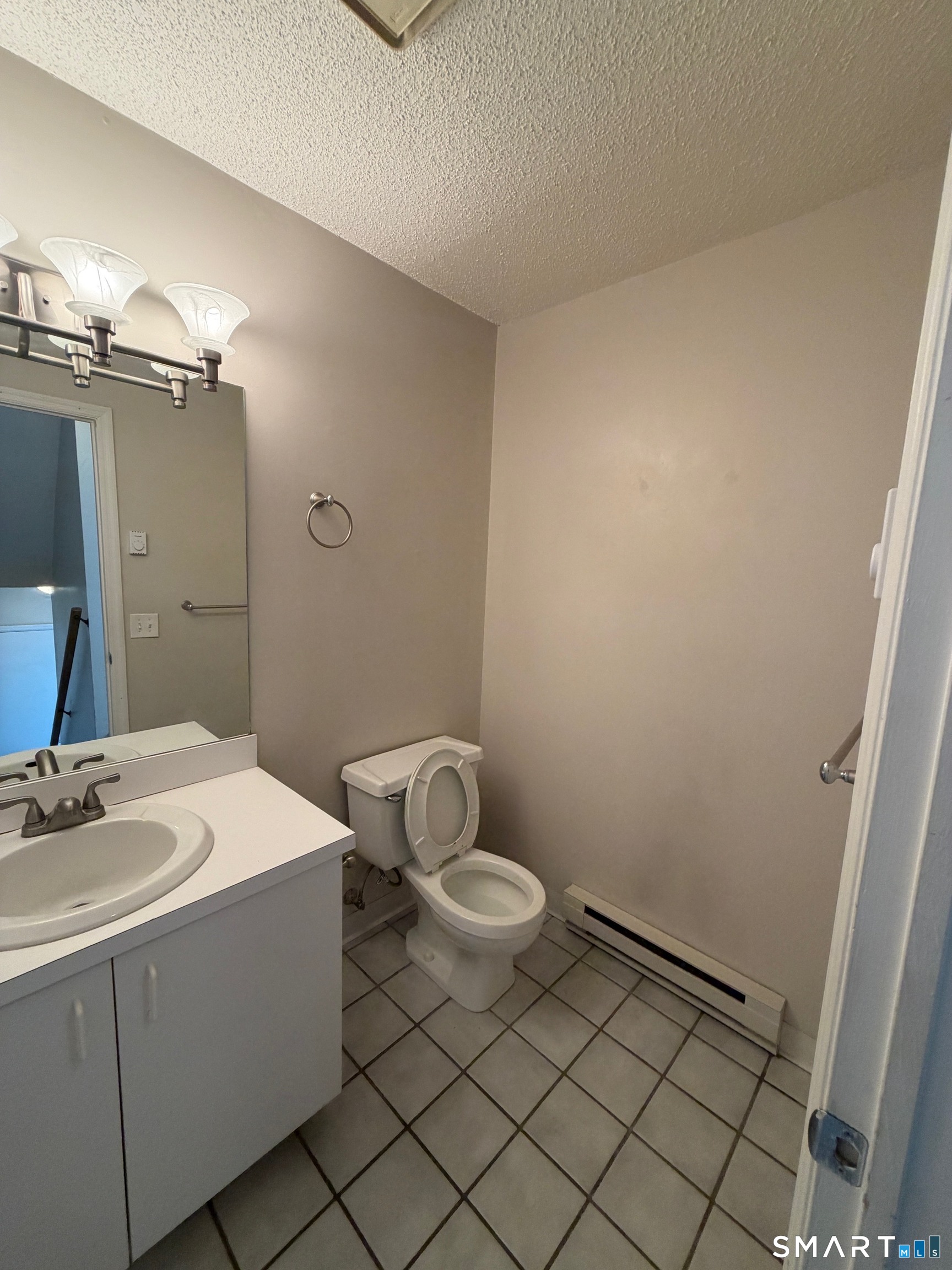 925 Oronoke Road, Unit 30F Waterbury, CT 06708 - Photo 3 of 12 a bathroom with a sink a toilet and a mirror