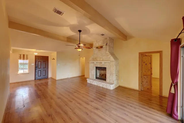a view of empty room with wooden floor and fireplace