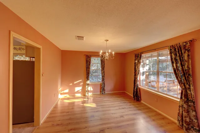 a view of a room with wooden floor and door