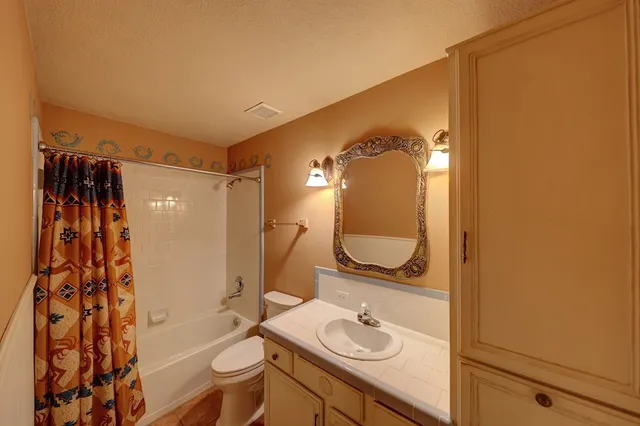 a bathroom with a granite countertop sink toilet and shower