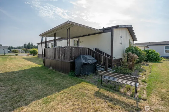 a view of a chair and table in the backyard of the house