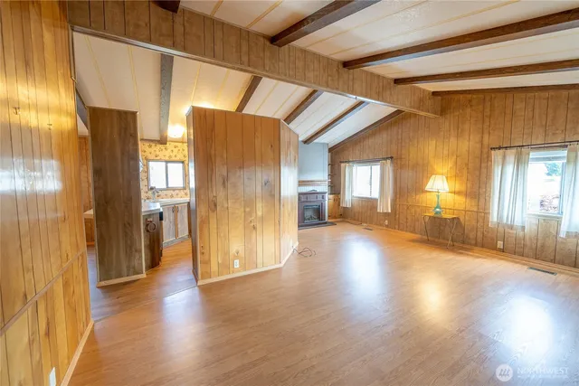 a view of a hallway with wooden floor and windows