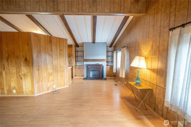 a view of an empty room with a fireplace and a window