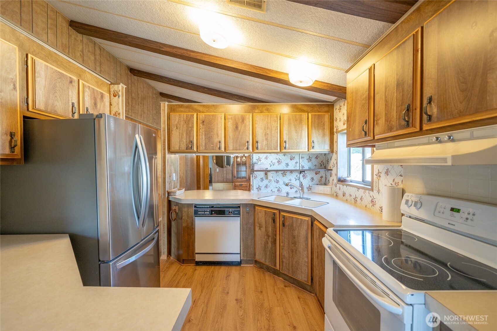57 Clemons Road, Unit 68 Montesano, WA 98563 - Photo 8 of 27 a kitchen with stainless steel appliances granite countertop a refrigerator a sink dishwasher a stove and white countertops with wooden floor