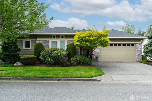 a front view of a house with a yard and potted plants