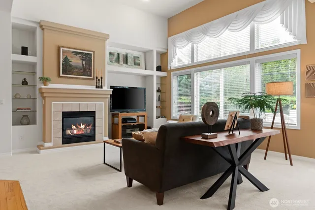 a living room with furniture a fireplace and a large window
