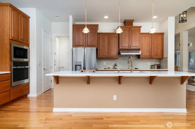 a kitchen with stainless steel appliances granite countertop a sink a stove and a refrigerator
