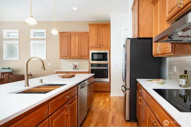 a kitchen with a sink stove top oven and refrigerator